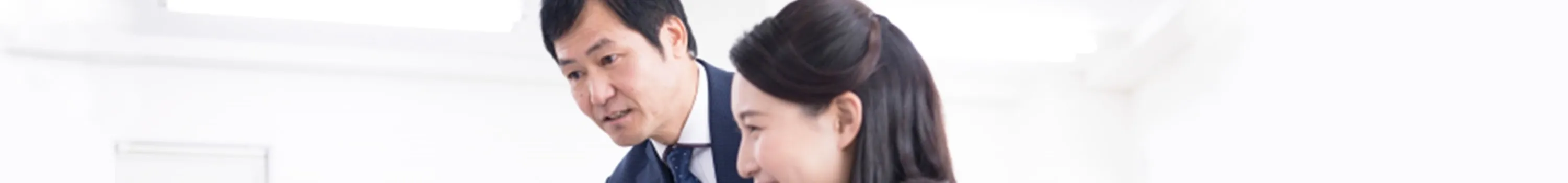 パソコン画面を見て談笑する男女