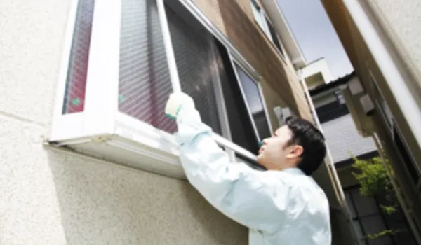 網戸の修理をする職人